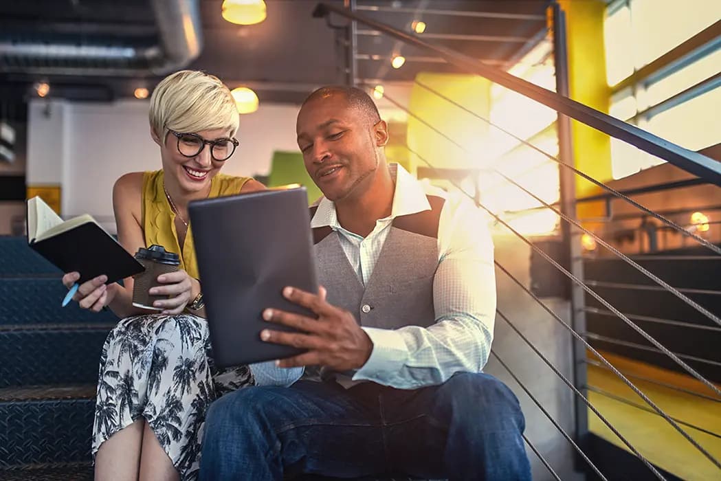 A consultant presenting solutions to a client; informal lounge, sunset light flooding the room