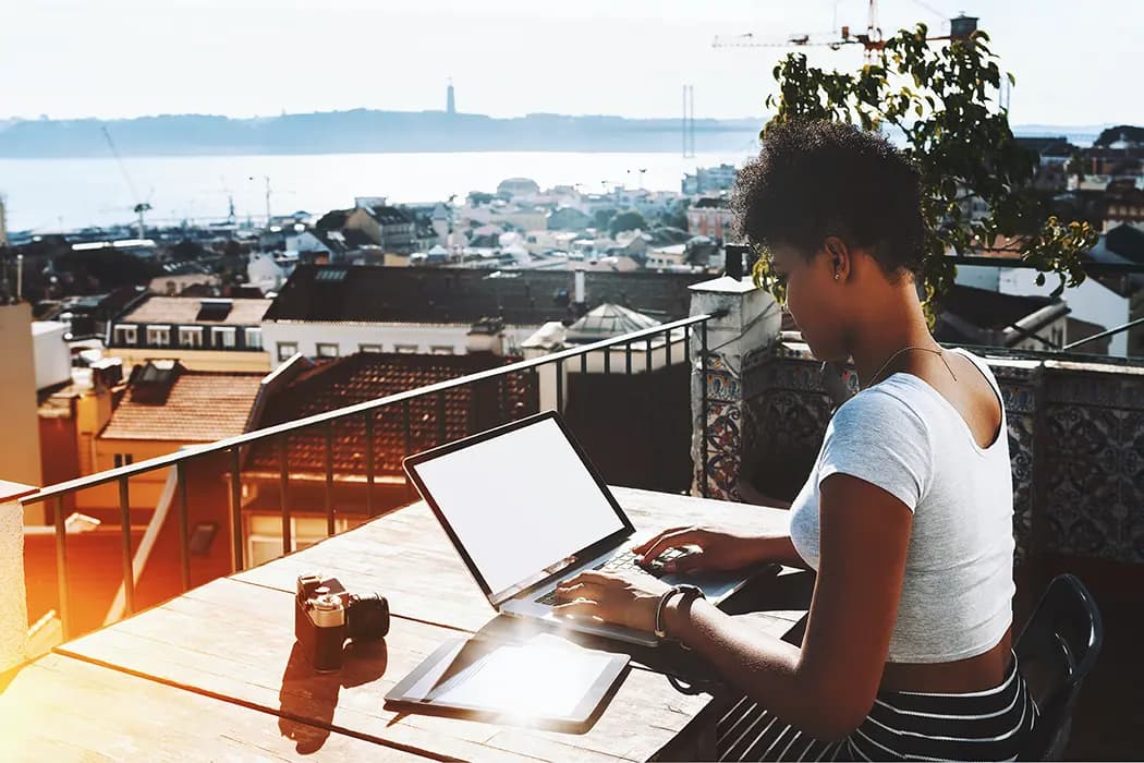 A digital nomad working on a terrace overlooking river Tagus in Lisbon