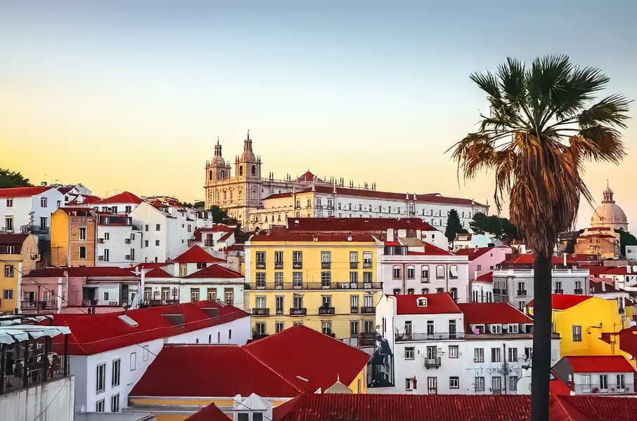 Lisbon at sunset with red rooftops and São Vicente de Fora monastery