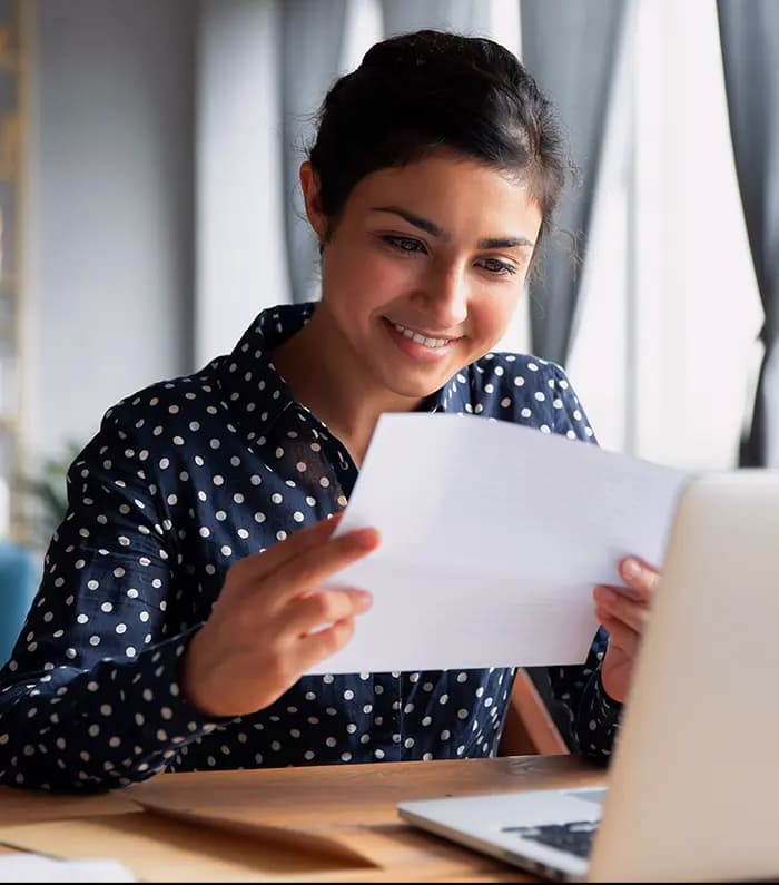 an happy adult female checking an utility bill