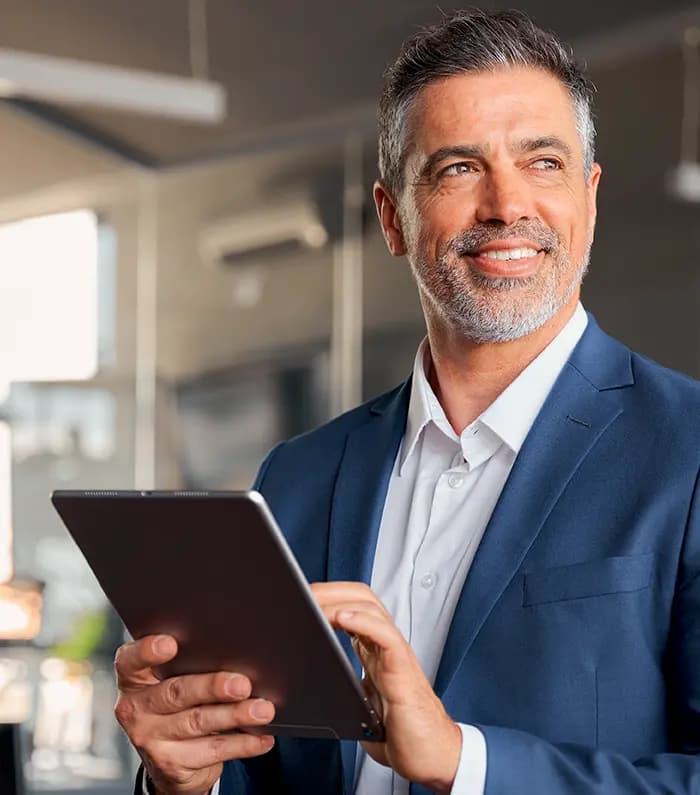 a confident 40 year old man with a tablet in his hands looking away