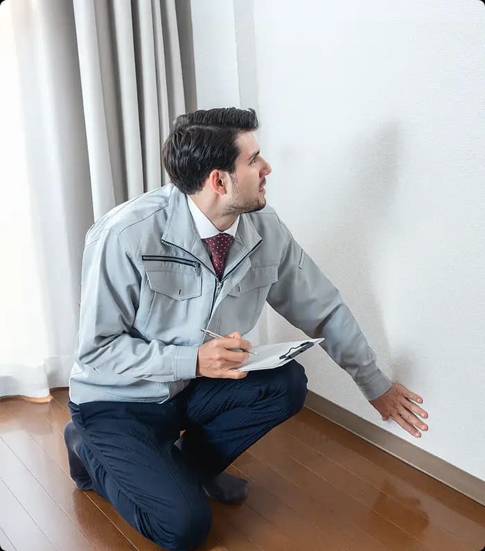 A technician inspecting the recent paint job on an apartment.