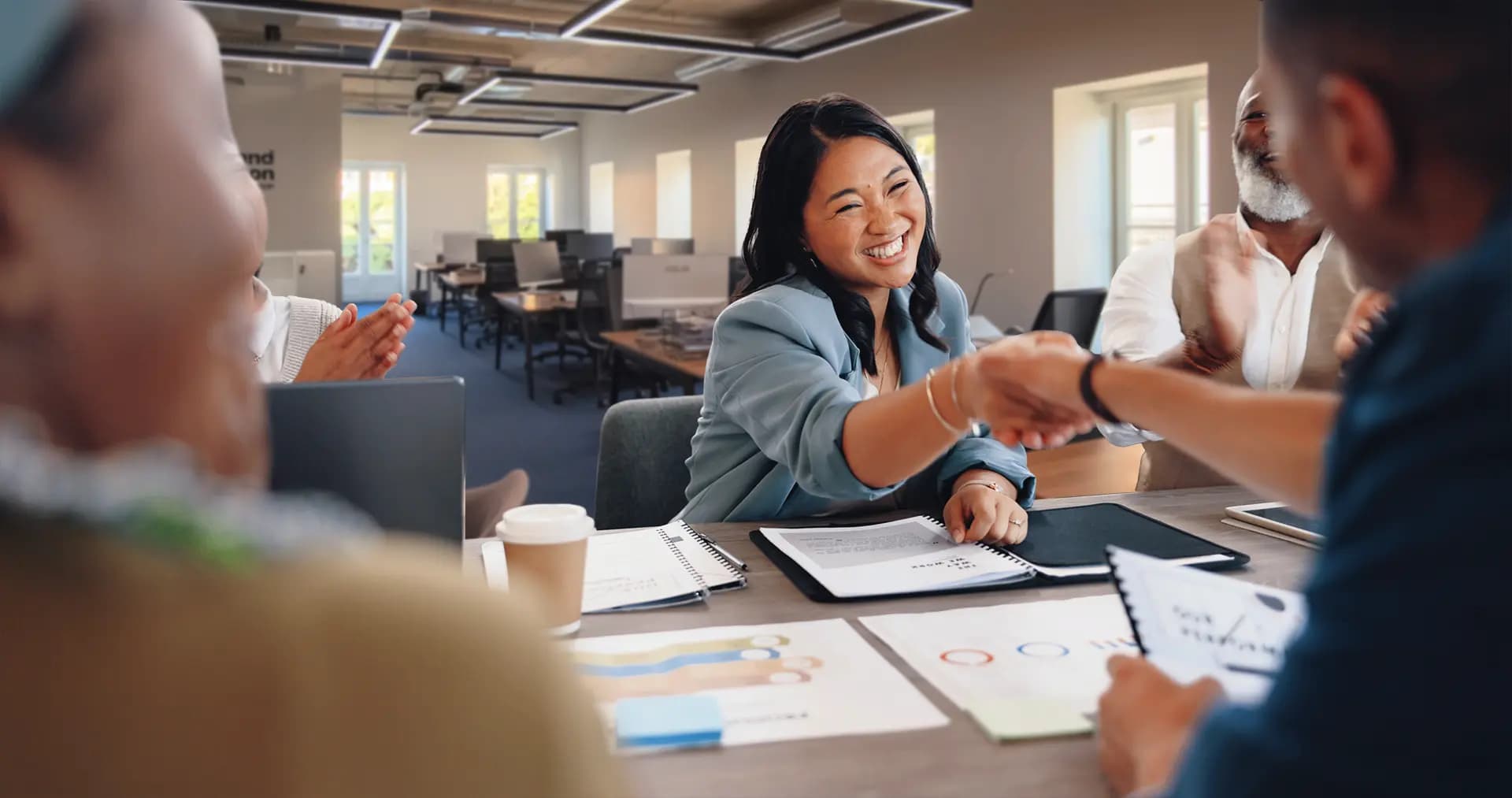 An happy client closing a deal at the open space Lisbon office of Portugal Homes